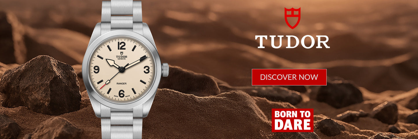 A silver Tudor watch with a cream dial is shown against a rocky desert background. The right side features the Tudor logo, a red 'DISCOVER NOW' button, and a red 'BORN TO DARE' badge.