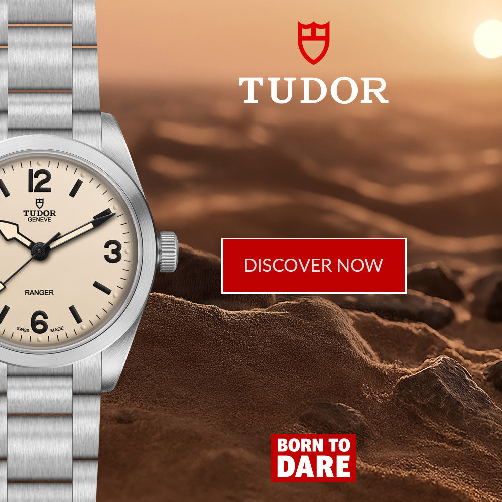 A Tudor watch with a silver metal bracelet and a cream-colored dial is shown on the left side against a desert landscape background at sunset. The right side features the Tudor logo, a red 'DISCOVER NOW' button, and a red 'BORN TO DARE' badge.